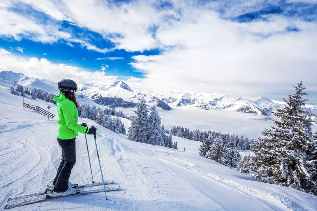 Eine Frau auf Skier blickt auf ein herrliches Bergpanorama.