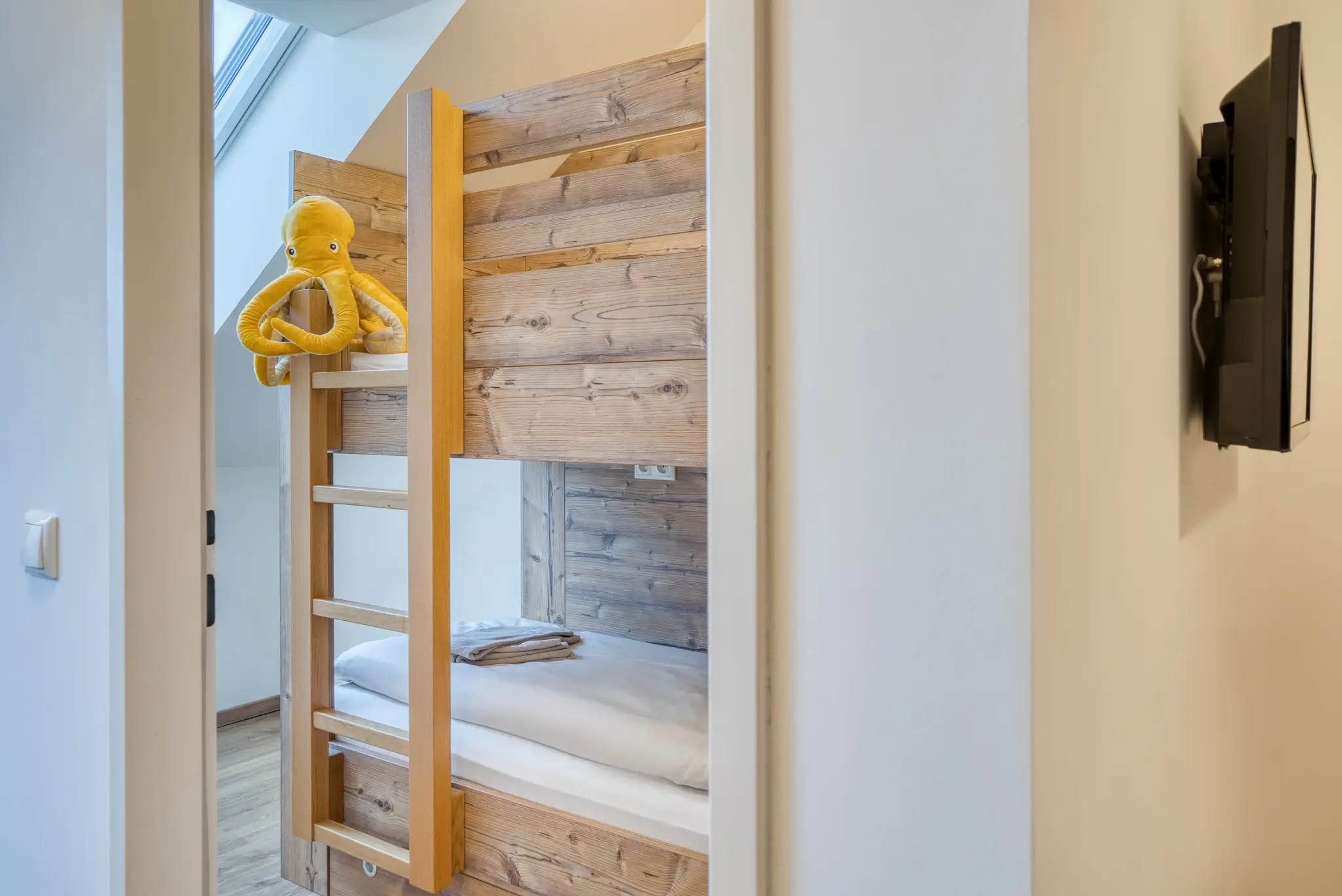 Schlafzimmer mit Stockbett im Skitopia Apartment im COOEE alpin Hotel Dachstein in Gosau.