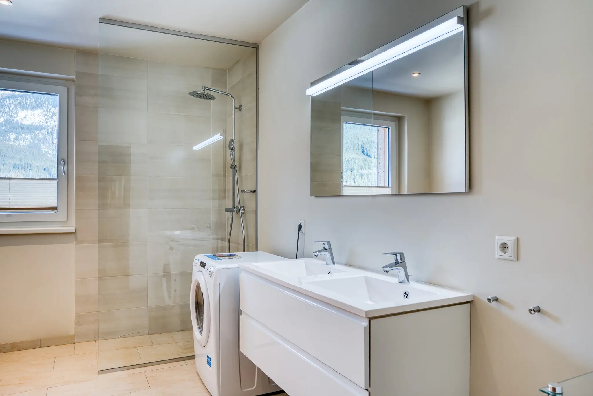 Ein Badezimmer mit Waschmaschine im Alpinomad Apartment im COOEE alpin Hotel Dachstein in Gosau.