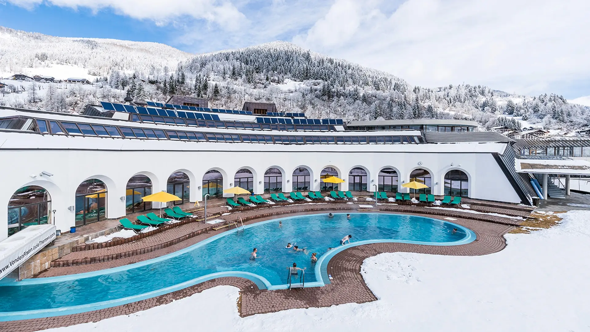 Das Thermal Römerbad von außen im Winter mit dem Outdoor Pool und Liegeflächen.