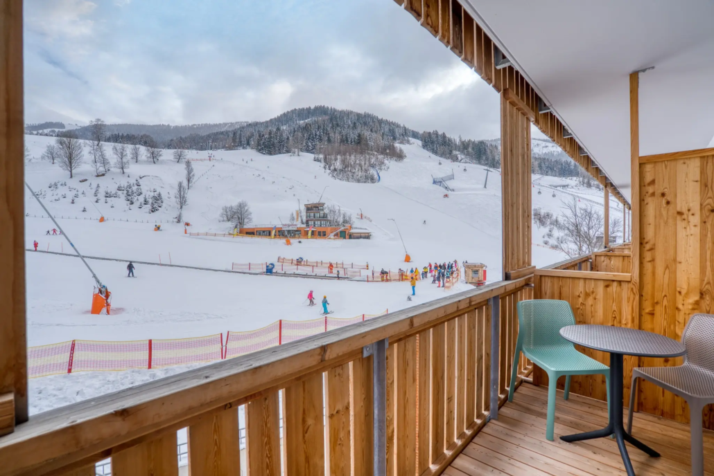 Ausblick vom Kaiserburg Zimmer im COOEE alpin Hotel Bad Kleinkirchheim auf die Piste und Skischule Brunner.