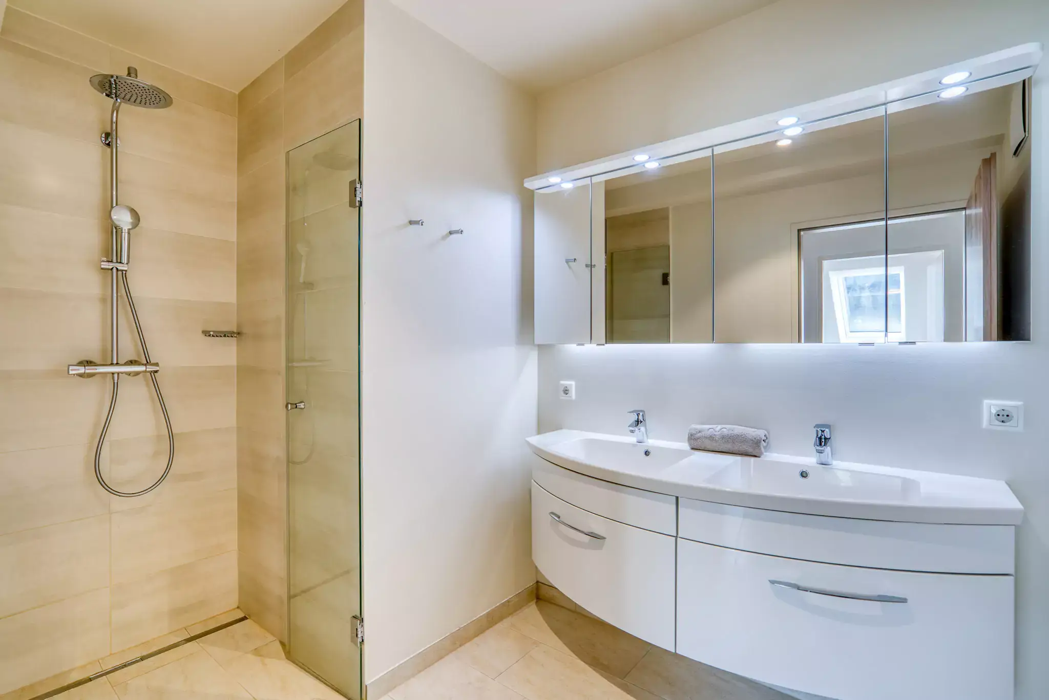 Bagno con doppio lavabo, specchio e doccia.