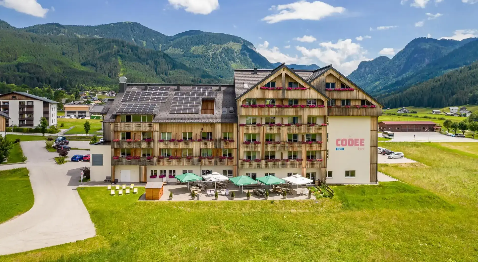 Das COOEE alpin Hotel Dachstein von außen mit Sonnenterrasse.