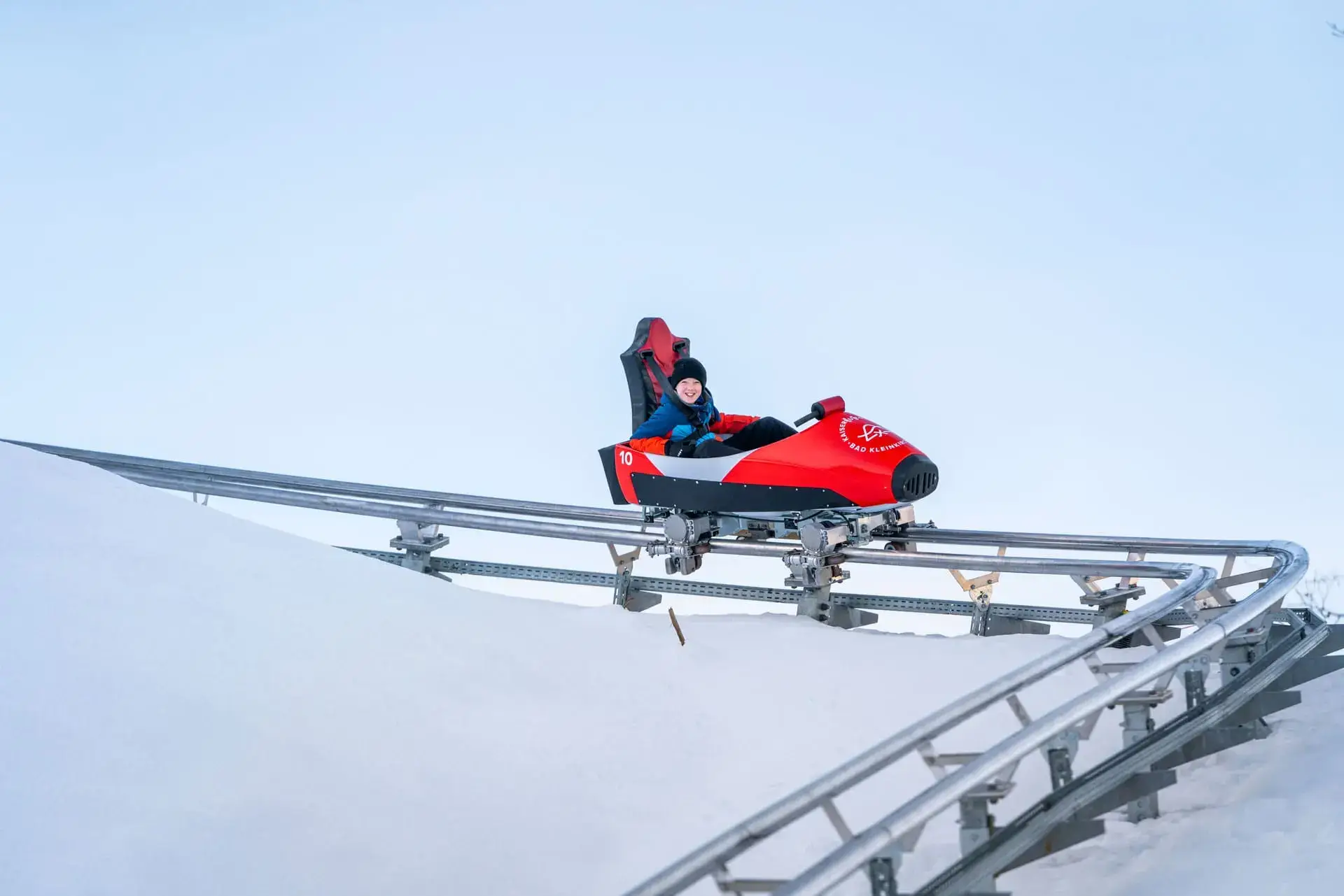 Kind beim Winterrodeln auf dem Alpine Coaster Kaiserburg Bob in Bad Kleinkirchheim – beliebte Winteraktivität für Familien im Skiurlaub in Kärnten.