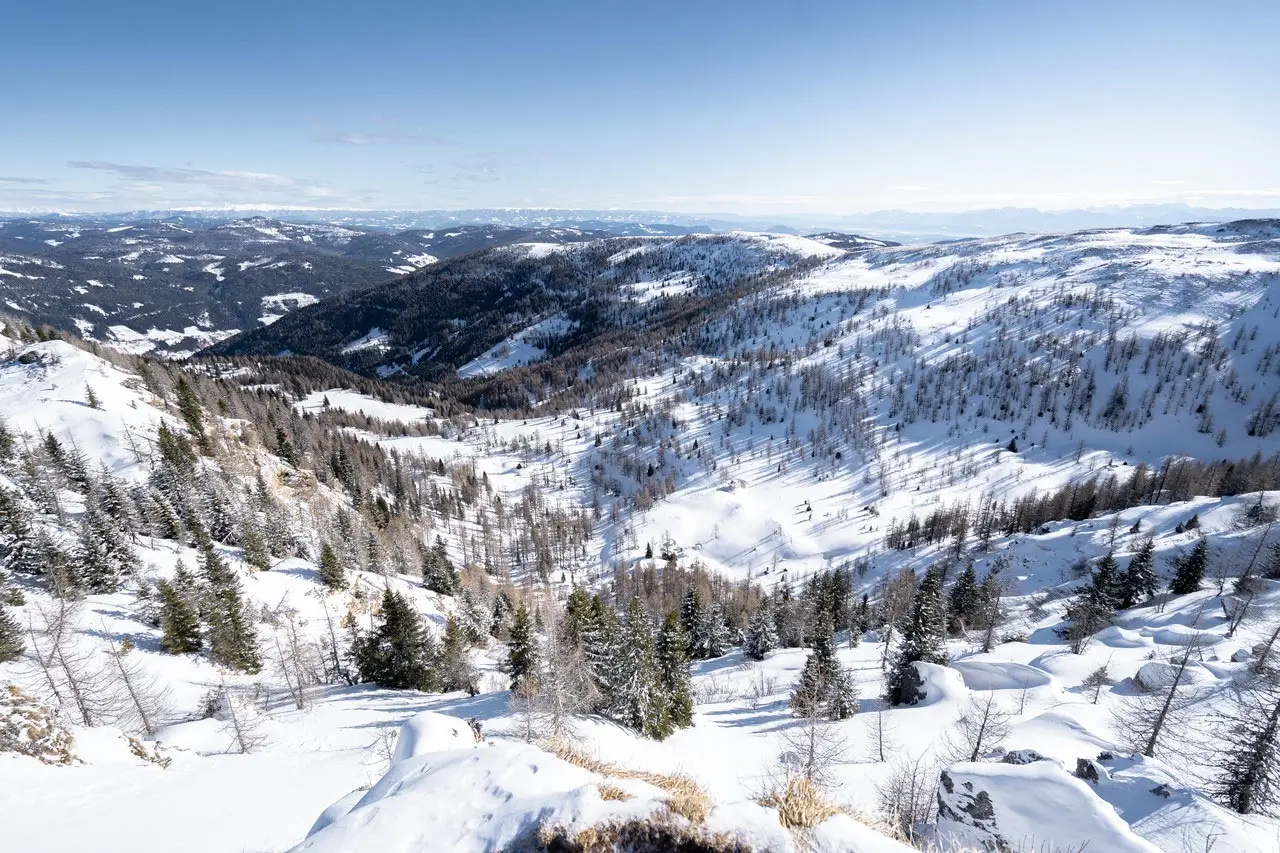 Panoramablick auf eine verschneite Berglandschaft.