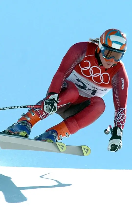 Skifahrer Rainer Schönfelder springt mit seinen Skiern über eine Kuppe.