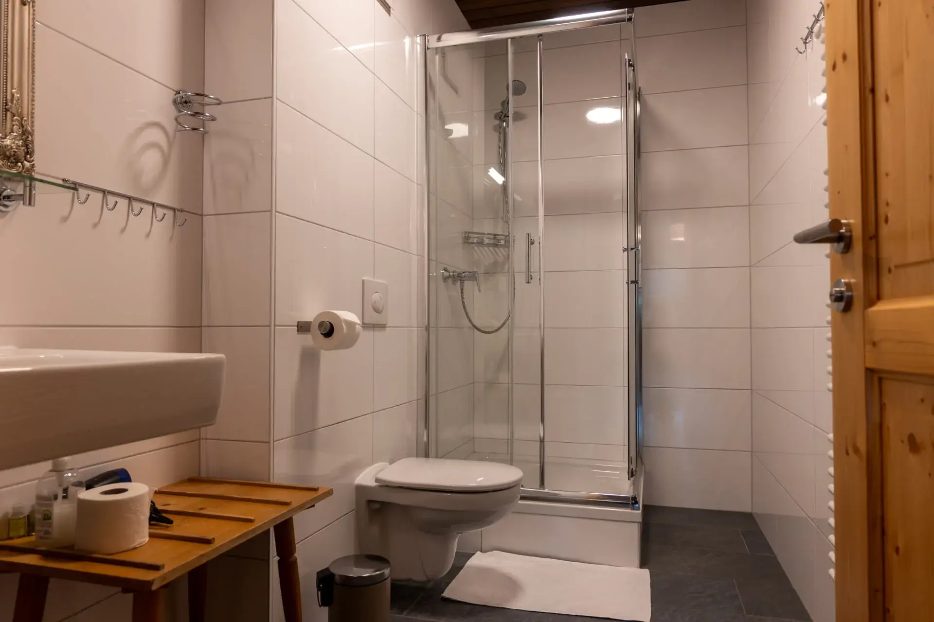 bagno moderno con doccia, WC e lavabo; specchio da parete argentato