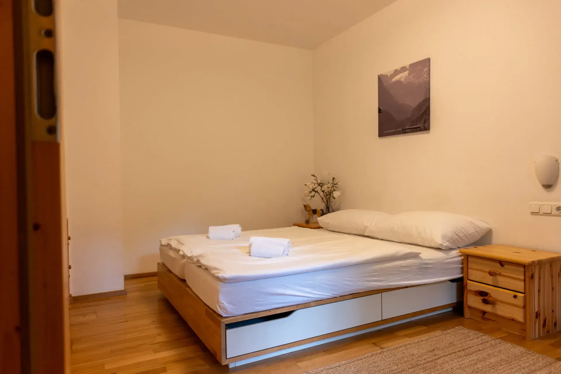 Spaziosa camera da letto nell'appartamento Toplitzsee dell'Ulmenhof, con letto matrimoniale, comodini e mobili in legno.