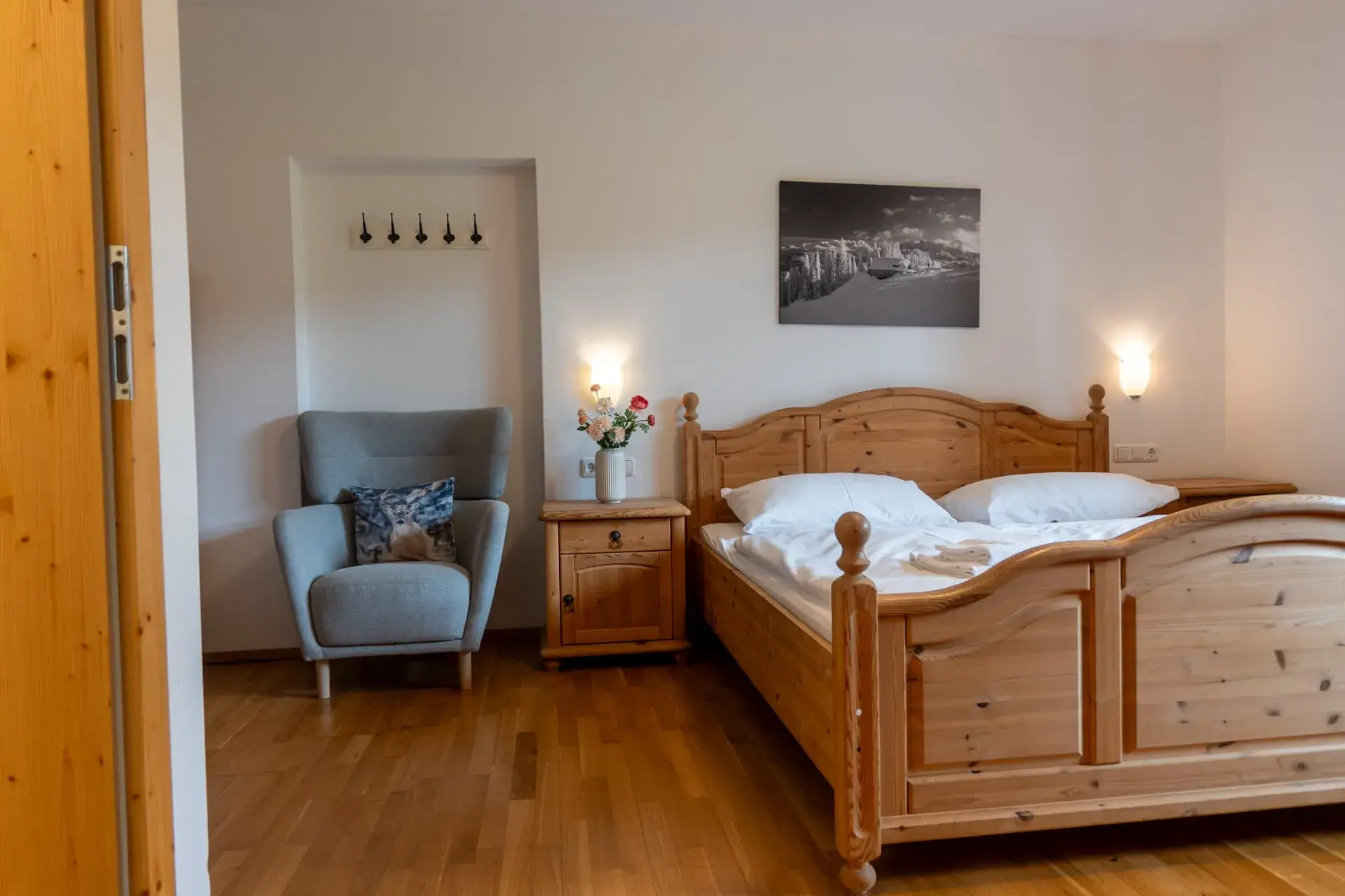 Spaziosa camera da letto nell'appartamento sul Traunsee a Gosau, con letto matrimoniale, poltrona da lettura e mobili in legno.