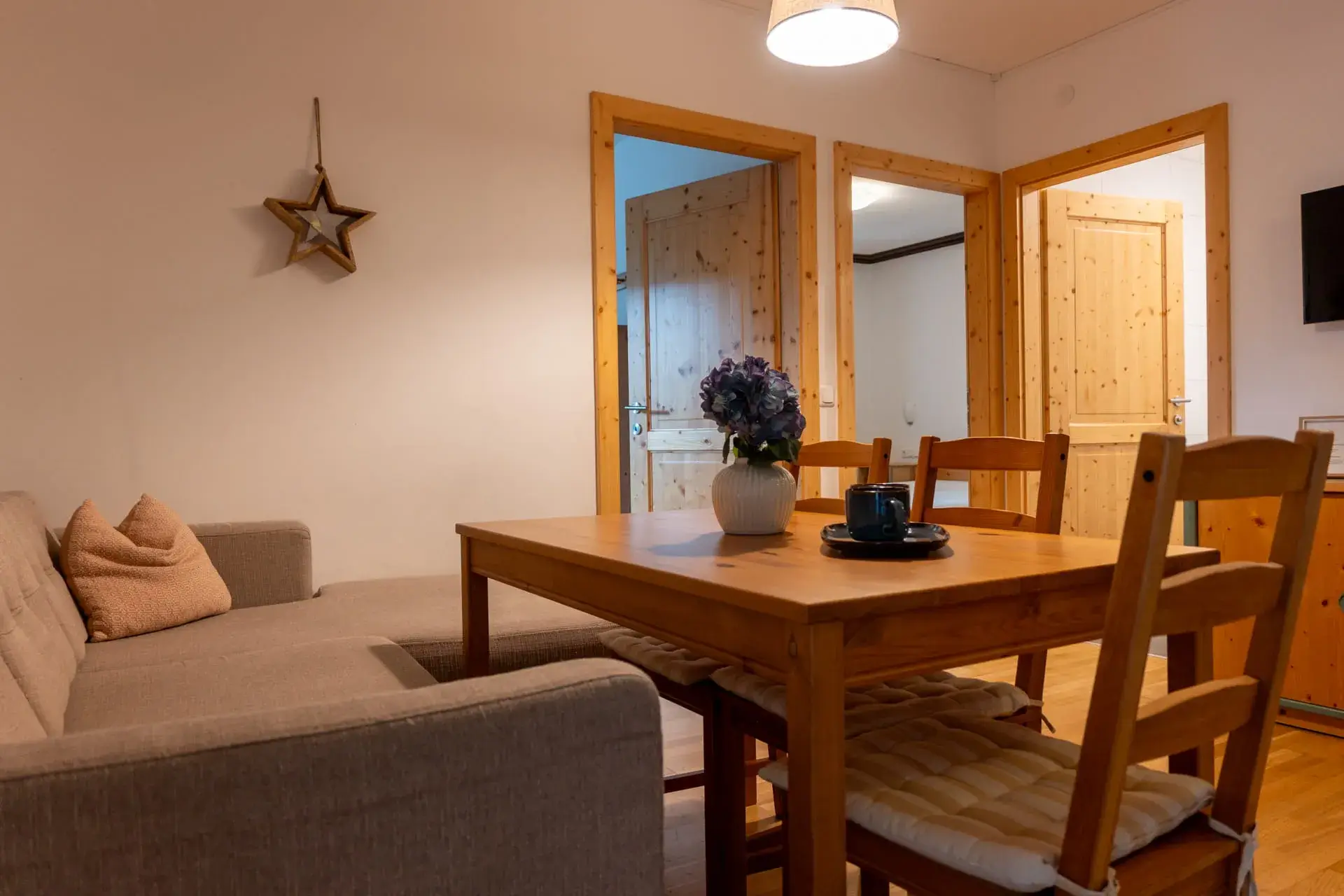 Bright living and dining area in the Wolfgangsee Apartment in Gosau, featuring a dining table, a sleeper sofa, and plenty of space for a relaxing vacation on Dachstein.