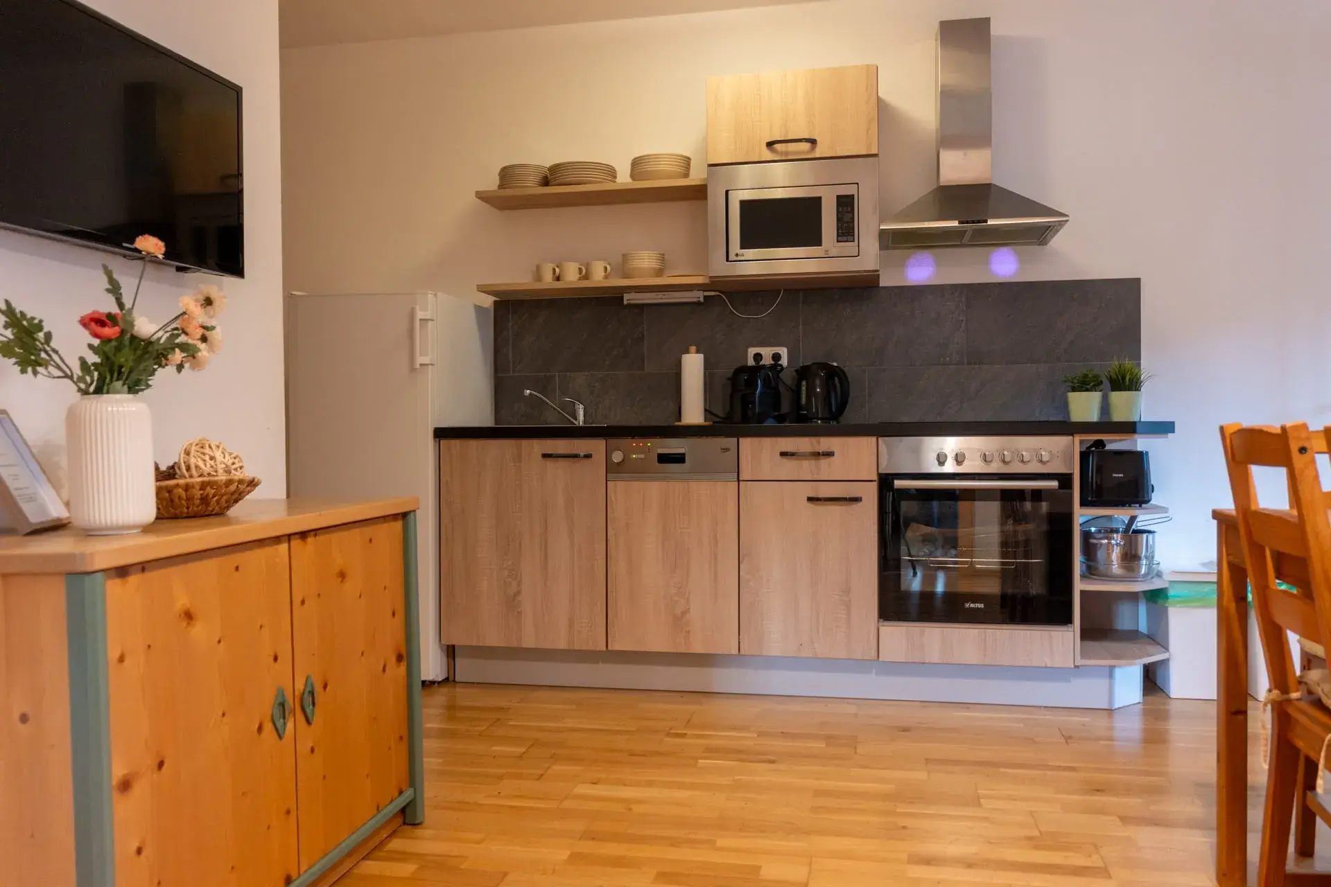 Fully equipped kitchen at the Wolfgangsee Apartment in Gosau, featuring a stove, oven, refrigerator, microwave, and coffee maker—perfect for a flexible vacation.