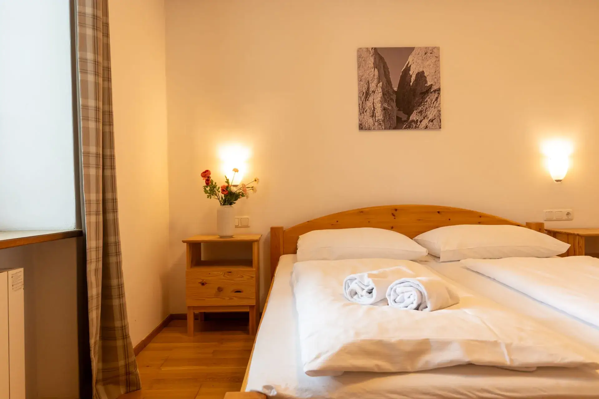 Bright bedroom in the Wolfgangsee Apartment in Gosau with a double bed and wooden furniture—comfortable accommodations near Hallstatt and Dachstein .