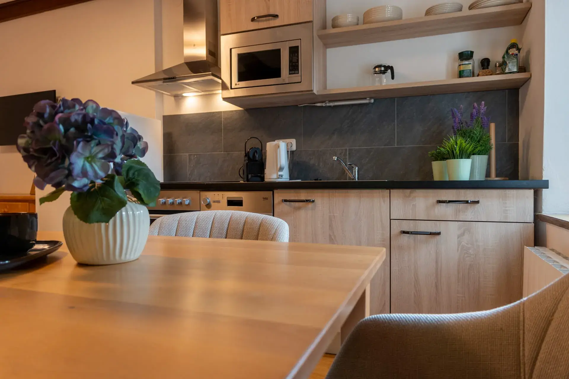 Cucina completamente attrezzata nell'appartamento Almsee dell'Ulmenhof a Gosau, con forno, microonde e macchina per il caffè: l'ideale per chi desidera cucinare da sé.