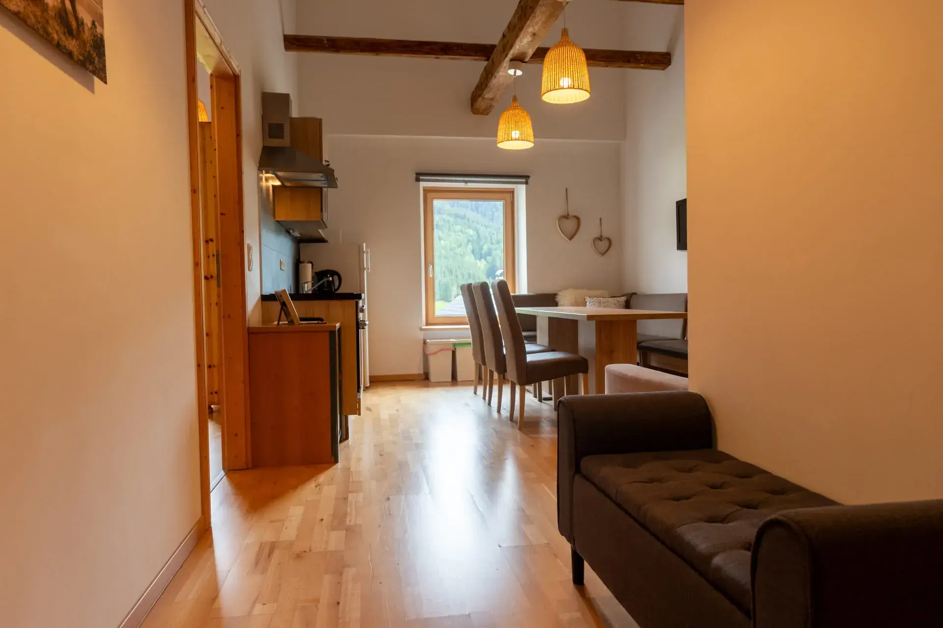 Vista sulla zona soggiorno/pranzo con cucina, tavolo da pranzo, divano e TV; interni nuovi e moderni; ambiente inondato di luce